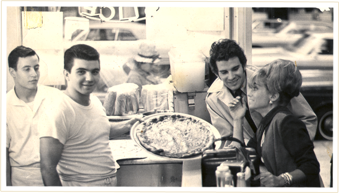 A young Nick Andrisano serving a pizza.