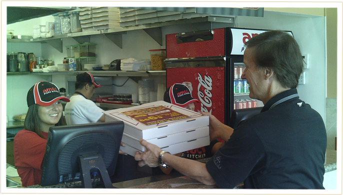 Our Ameci's Team Members Delivering 3 boxes of pizza to a happy customer.
