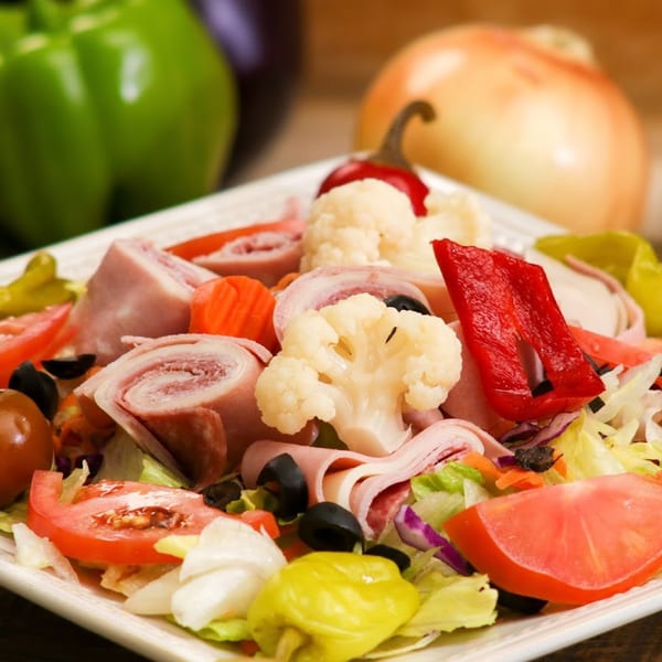 Ameci Pizza & Pasta's antipasto salad with ham, salami, cheese, olives, tomatoes, and peppers.